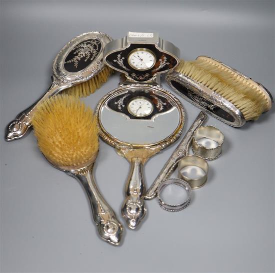 A George V silver and tortoiseshell pique mounted timepiece, S.W. Goode & Co, Chester, 1920, 10cm and a similar toilet set(a.f.)